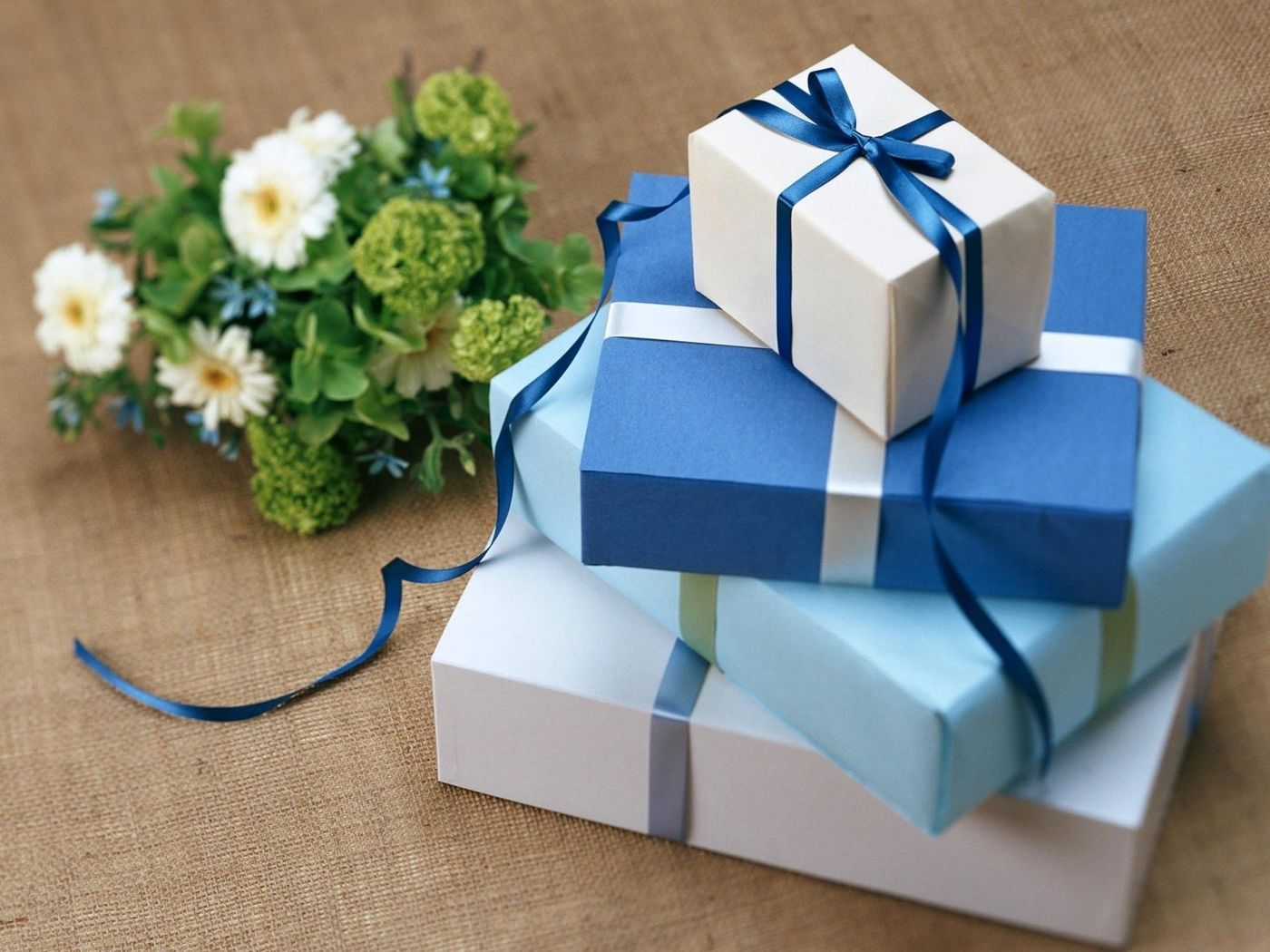 Stacked blue and white gift boxes tied with ribbon